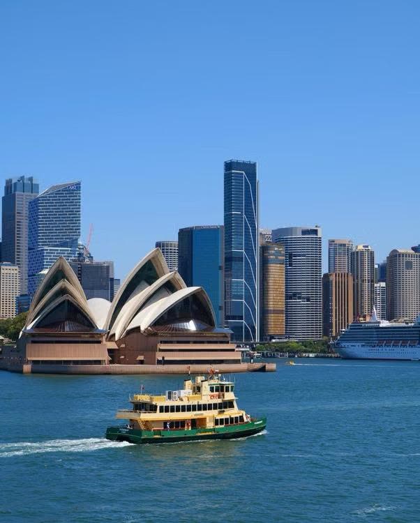 Opera House de Sydney e a baía com barco, na Austrália